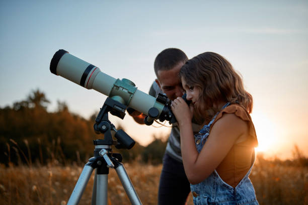 istock Father and daughter observing the sky with a telescope. 1171079553