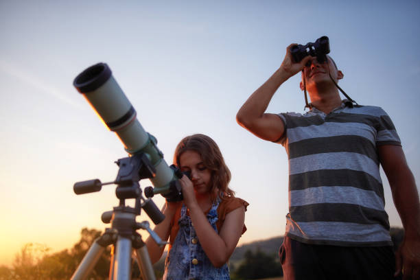 istock Father and daughter observing the sky with a telescope. 1171079636