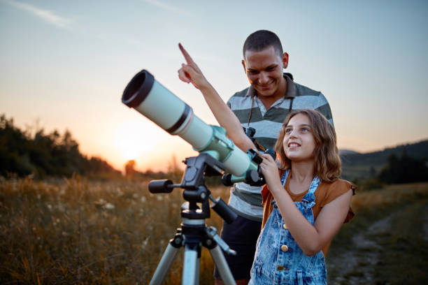 istock Father and daughter observing the sky with a telescope. 1171079773
