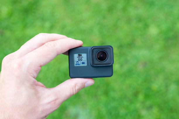 istock Action camera in hand close-up. Lens and small display with resolution, battery and memory card information. 1171081006