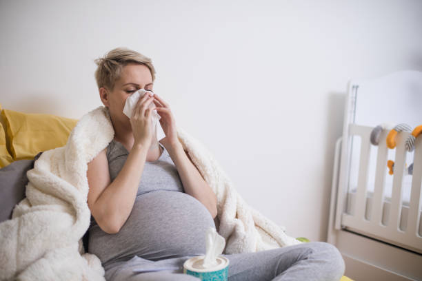 pregnant woman having a headache and morning sickness stock photo