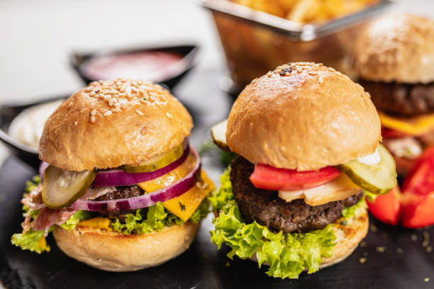 istock Three delicious mini burgers on a granite board 1171081298