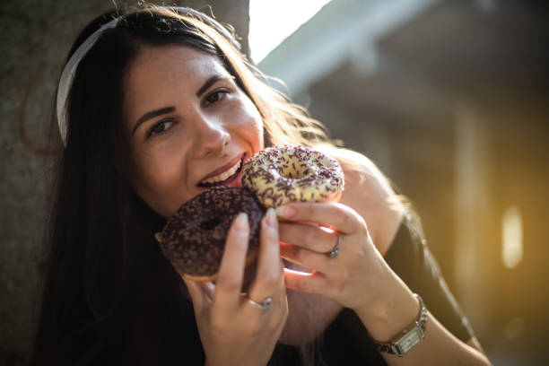 istock Happy woman holding donuts 1171083023