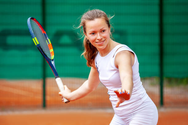 jogador de ténis fêmea bonito que joga o tênis. - tennis forehand people sports and fitness - fotografias e filmes do acervo