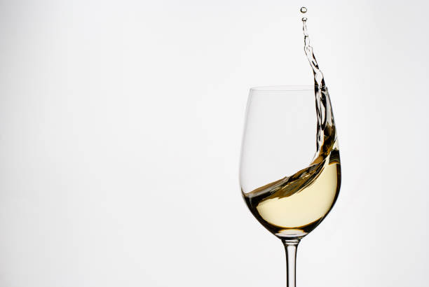 white wine splashing from an elegant wineglass - wine glass white wine wineglass imagens e fotografias de stock