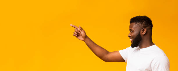 istock Black millennial guy pointing away at free space 1171087659