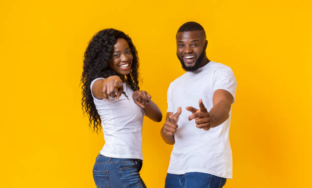 istock Cheerful afro couple pointing fingers at camera 1171088587