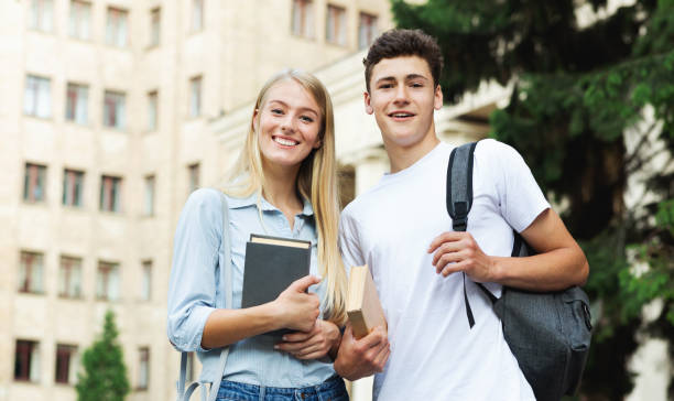 istock Happy university students holding books and smiling to camera 1171088599