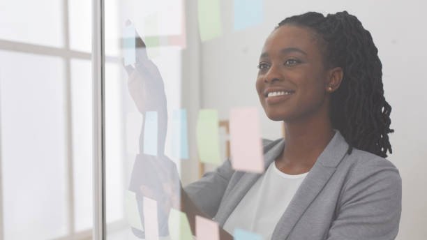 istock African American Business Lady Reading Sticky Notes On Glass Board 1171088905