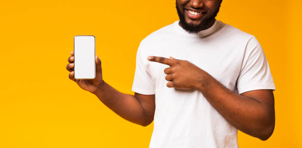 istock Man holding smartphone with blank screen and pointing on it 1171089911
