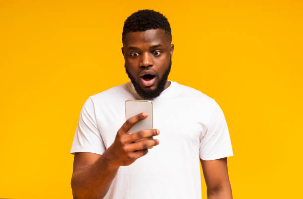 istock Shocked african man looking at smartphone screen in amazement 1171090026