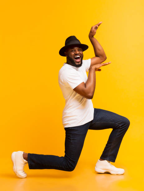 istock Funny african guy dancing in egypt style on yellow background 1171090206
