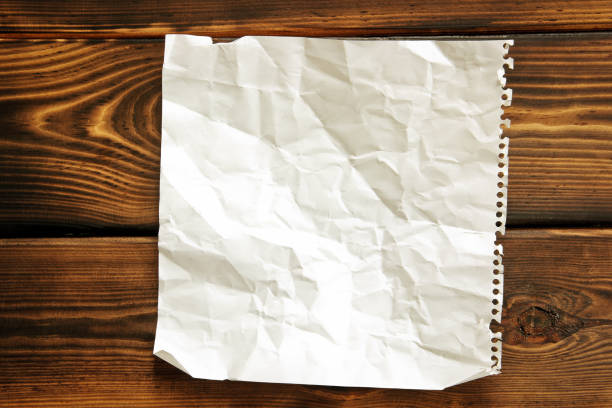 istock Paper. Crumpled paper on wooden background 1171091907