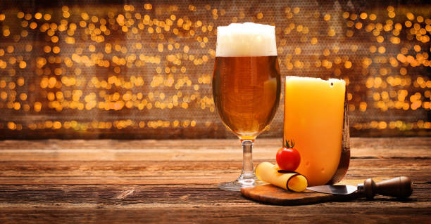 istock Yellow cheese appetizer with beer on wooden vintage background 1171092464