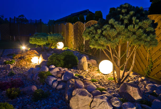 домашний сад ночью, освещенный глобусом формы огней - formal garden ornamental garden lighting equipment night стоковые фото и изображения