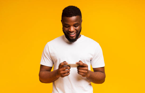 istock African man playing video game on mobile phone and smiling 1171092755