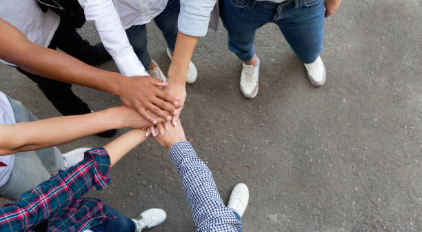 istock Multiracial students joining hands together in cooperation 1171093116