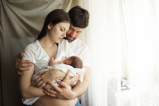 Father and mother with a newborn son. New young multi-generation family Father and mother with a newborn son. New young multi-generation family. Breast-feeding cute pregnant woman with gift stock pictures, royalty-free photos & images