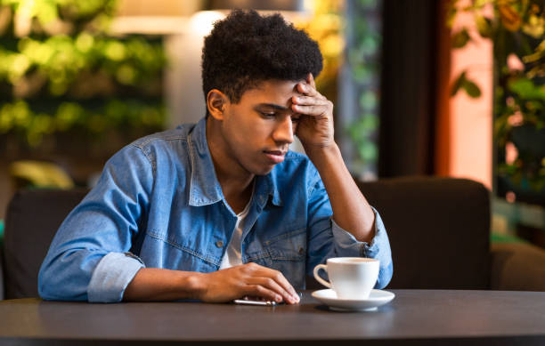 istock Upset afro teenager sitting alone at cafeteria 1171095112