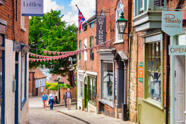 2 July 2019: Lincoln, UK - Steep Hill, the city's famous historic street, with independent shops, cafes and tourists walking up the hill.