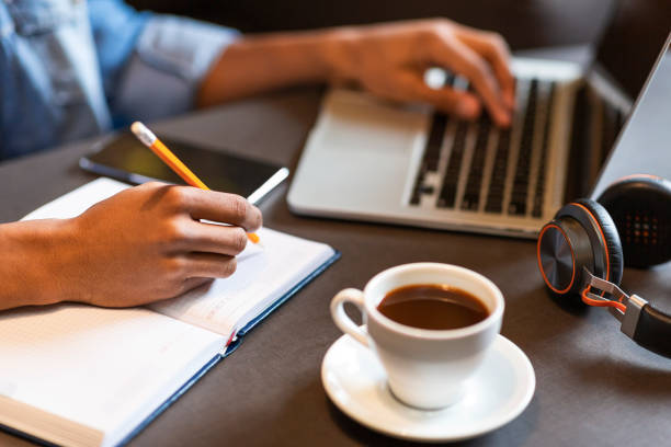 istock Hands of male blogger making notes at cafe 1171095659