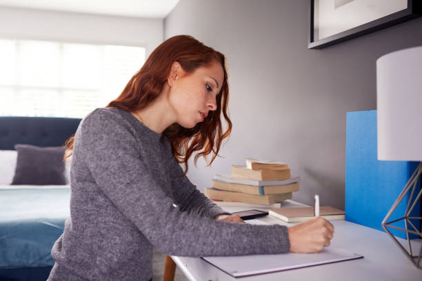 istock Female College Student In Shared House Bedroom Studying Sitting At Desk 1171099177