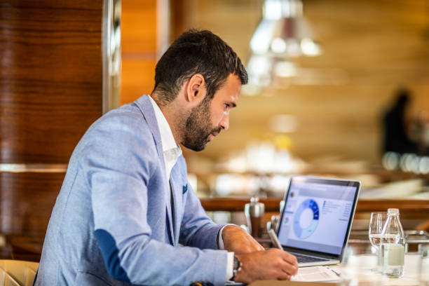 istock Small business entrepreneur analyzing financial flows from a pie chart on his laptop while sitting in an upscale restaurant 1171102869