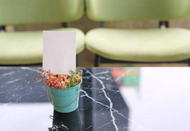 White blank paper label menu frame in mini flower pot on table at Bar restaurant.