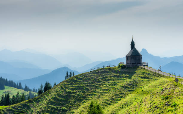 vue panoramique du bâtiment et des montagnes contre le ciel clair - church spire photos et images de collection