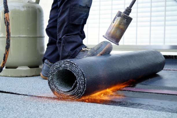 Flat roof installation with propane blowtorch during construction works with roofing felt. Heating and melting bitumen roofing felt. stock photo