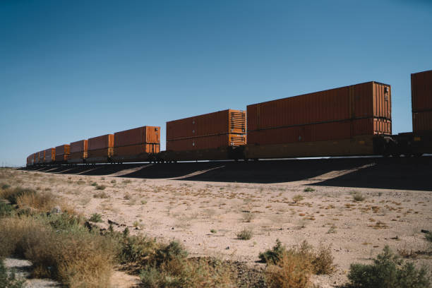 istock Freight engine locomotive transiting cargo on developed railroad infrastructure in wild nature lands, train wacons and containers with copy space for logistic service name or logo in desert environment 1171114531