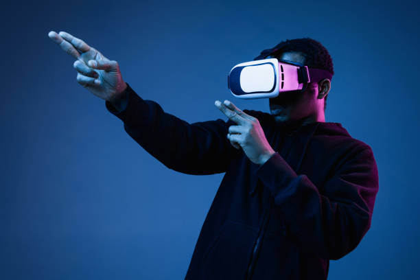istock Young african-american man's using VR-glasses in neon light 1171119584