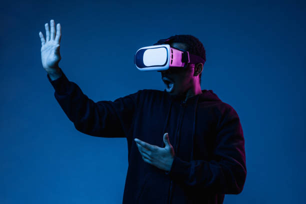istock Young african-american man's using VR-glasses in neon light 1171119600