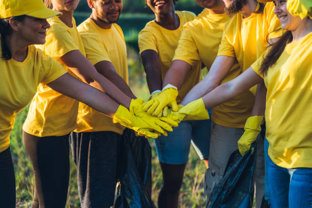 istock Group of volunteers put hands together 1171119659
