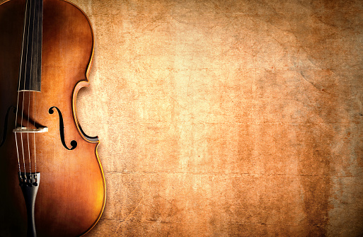 Cello resting against a blank grunge background with copy space