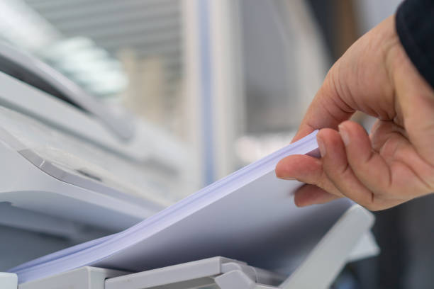 istock Business printer / printing documents in office concept: Businessman press white paper in laser printed cartridge feeder, scanner machine for copy document to report in busy modern offices background 1171123087