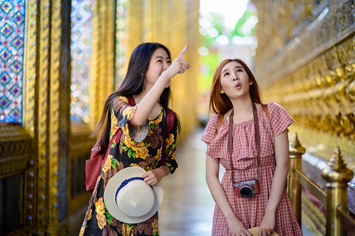 young tourist women walking talking and looking at the palace temple in Bangkok of Thailand, Emerald Buddha Temple, Wat Phra Kaew, Bangkok Royal Palace popular tourist place
