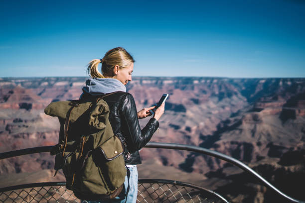 istock Smiling young hipster girl wanderer with backpack checking good mobile connection hiking on touristic route in mountains, positive female traveler sending messages on smartphone  exploring wild nature 1171124240