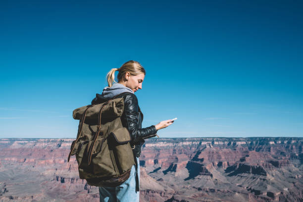 istock Cheerful female traveler with backpack using roaming data connection for blogging during wanderlust trip, smiling hipster girl satisfied with mobile network coverage connecting with friend on cellular 1171124298