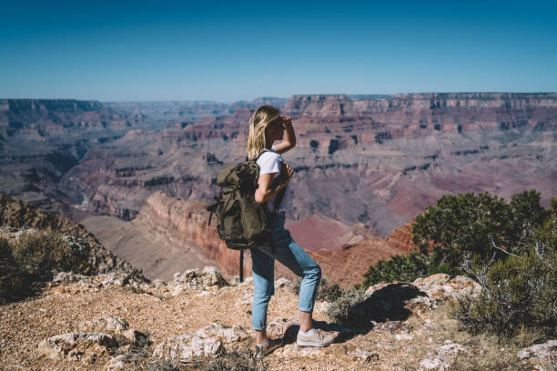 istock Female traveler with backpack enjoying trip while hiking on touristic route in wild environment, hipster girl wanderlust observing beautiful scenery of Arizona National Park standing on high hill peak 1171124319