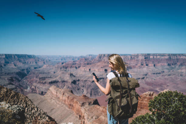 istock Young hipster girl reading message on smartphone standing on mountains viewpoint using roaming, female tourist with backpack using good mobile data connection in nature for communicating during tour 1171124329