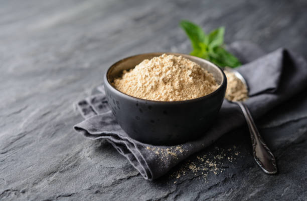 Dietary supplement, Maca root powder in a bowl and spoon with copy space stock photo