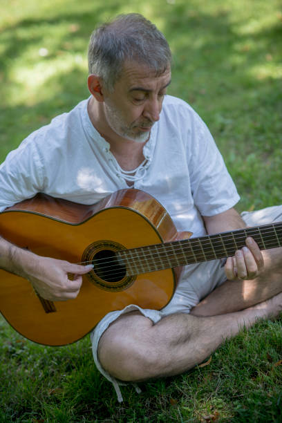 istock Senior flamenco guitar player practicing his art in a public park 1171127186