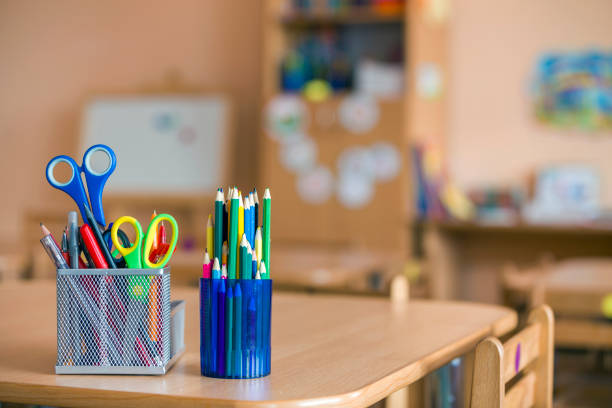 istock Stack of notebooks, colorful drawing pencils and stationery arrangement on copy space background. 1171130142