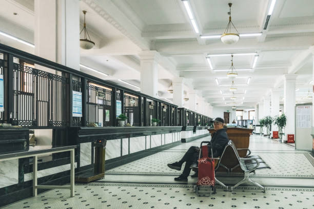 Shanghai, China - April 19, 2018: chinese man sitting on bench in the waiting area of the general post office building