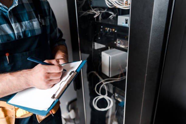 istock cropped view of workman holding clipboard while writing near wires and cables 1171131756