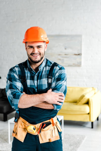 istock happy worker in safety helmet looking at camera while standing with crossed arms 1171131906