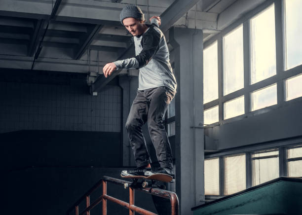 istock Young skateboarder performing a trick on mini ramp at skate park indoor. 1171131998