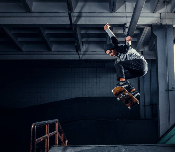 istock Young skateboarder performing a trick on mini ramp at skate park indoor. 1171132065