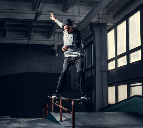 istock Young skateboarder performing a trick on mini ramp at skate park indoor. 1171132114